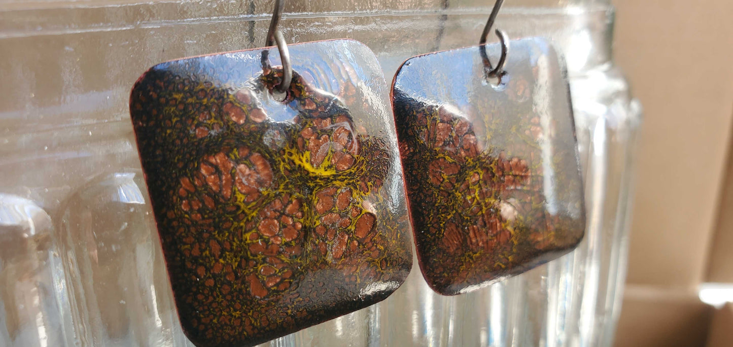 Pair of square copper earrings with a textured glass surface.