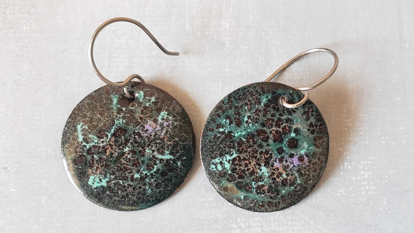 Pair of brown round copper earrings with a speckled design on a white background