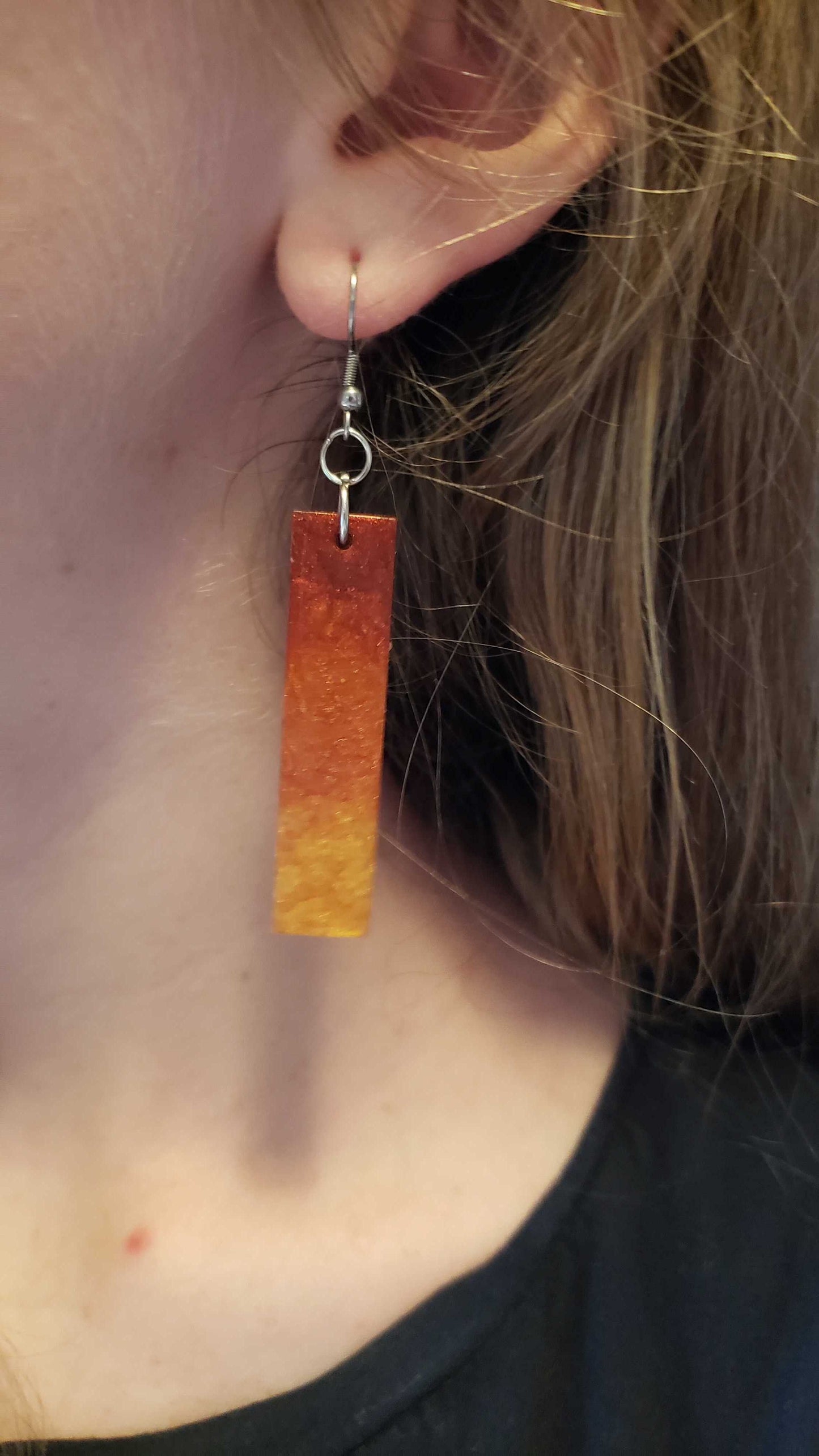 Flame fire colored earring worn by a person