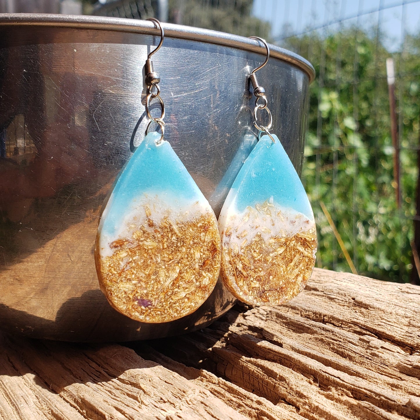Teardrop-shaped earrings with gold and blue design inspired by the ocean