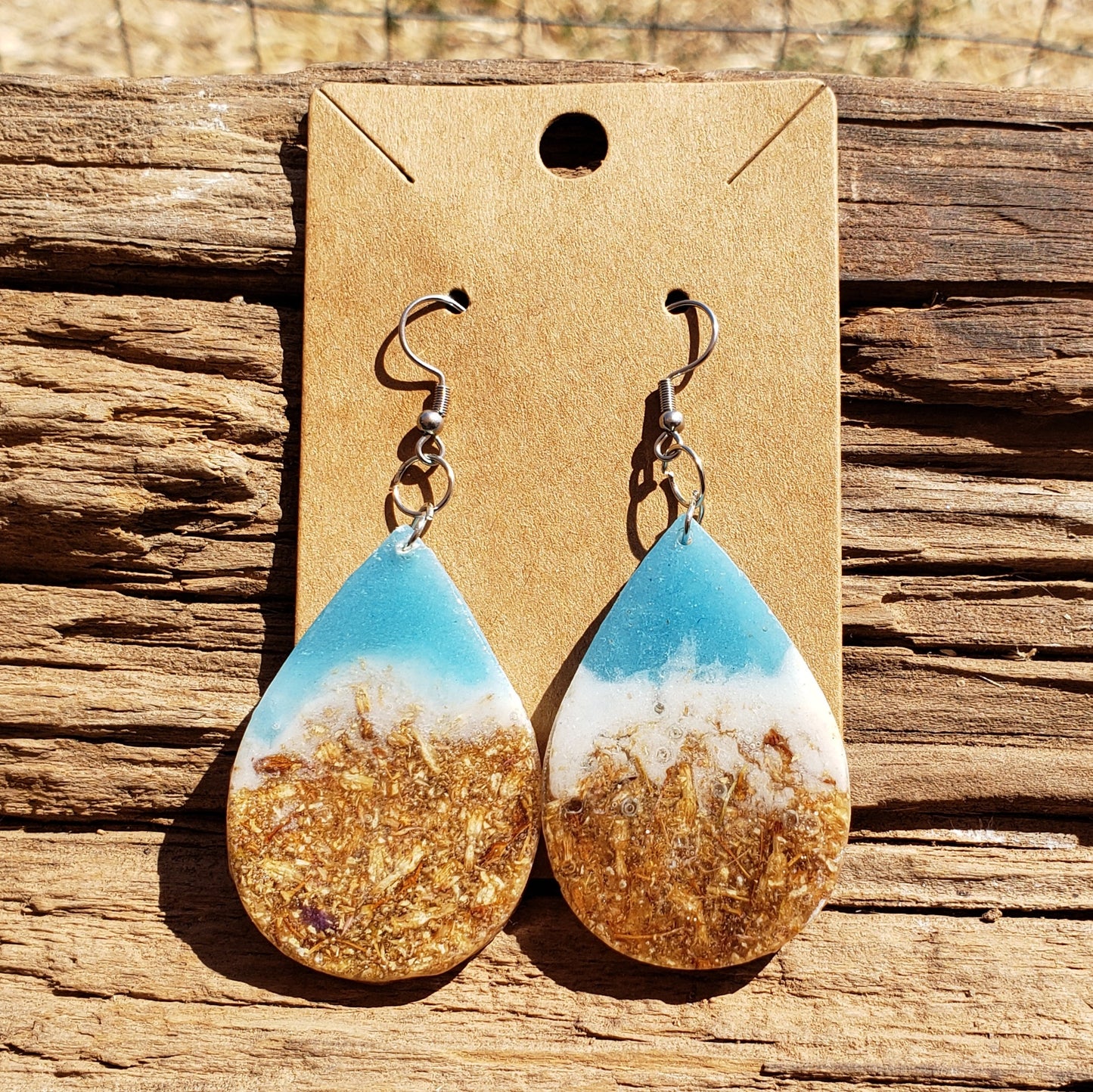 Teardrop-shaped earrings ocean inspired with gold dried flowers and white and blue design