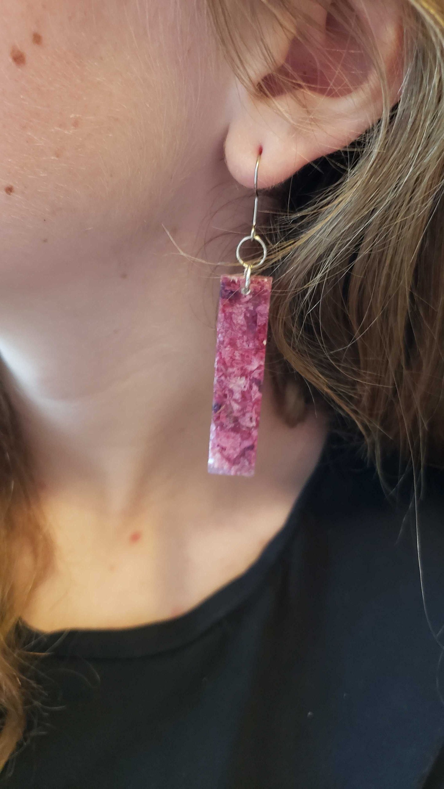 Close-up of a person wearing pink floral earrings.