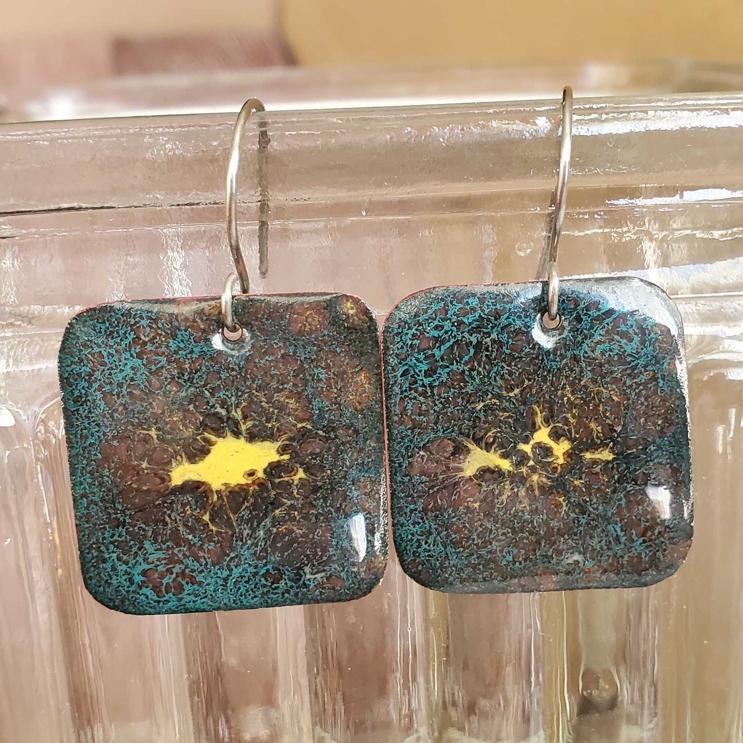 Pair of rectangular copper enamel earrings with a textured blue brown and yellow surface