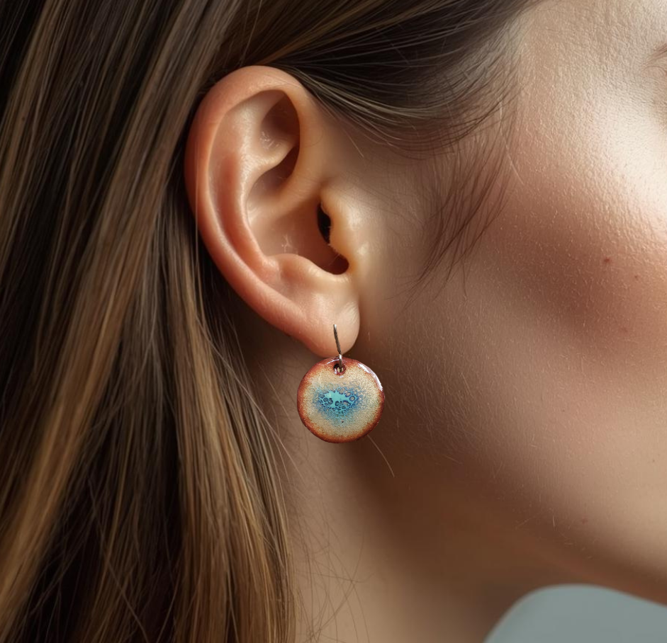 Close-up of a colorful copper enamel earring with a blurred background