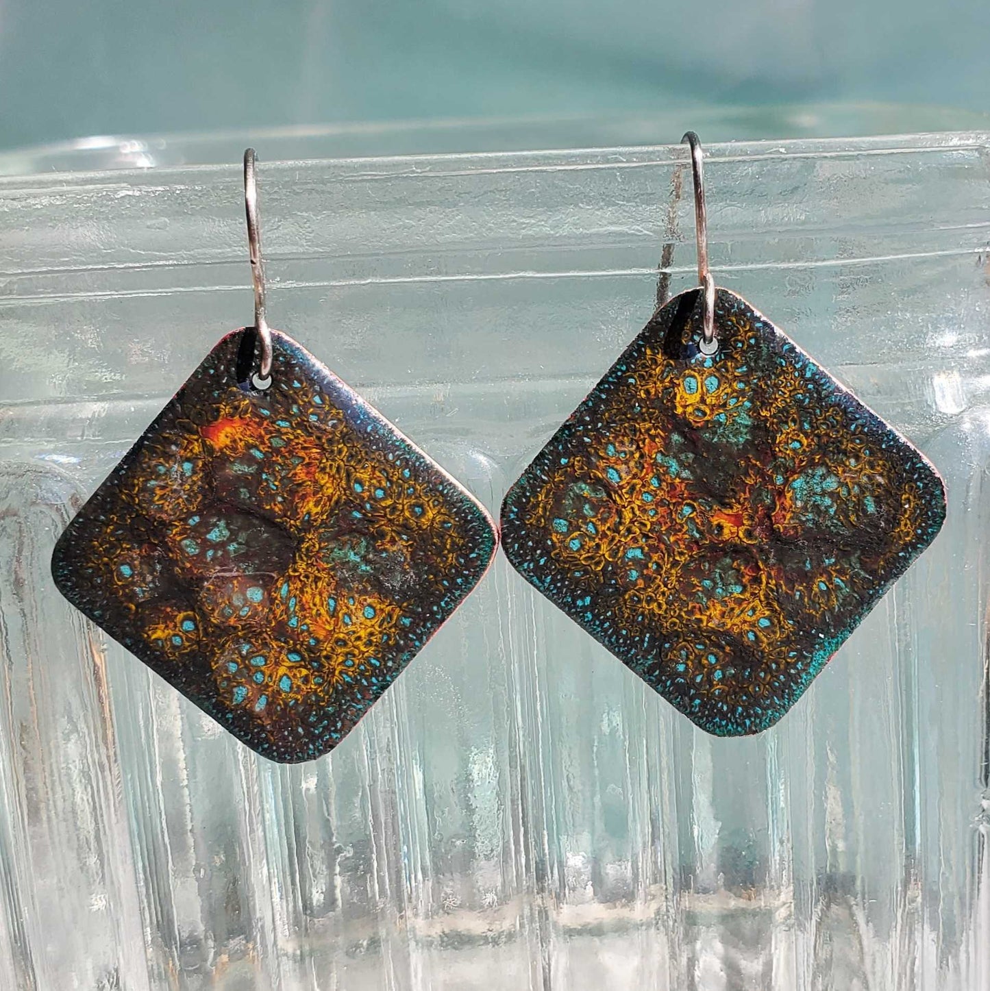 Square copper enamel earrings with a textured, multicolored design