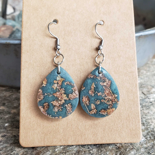 Teal teardrop earrings with dried leaves floral design on a beige card