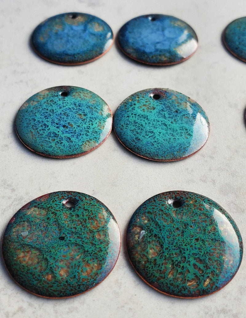 Blue copper earrings with a speckled pattern on a light gray background