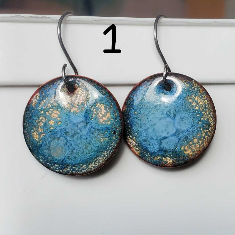Pair of blue and copper speckled earrings on a white surface