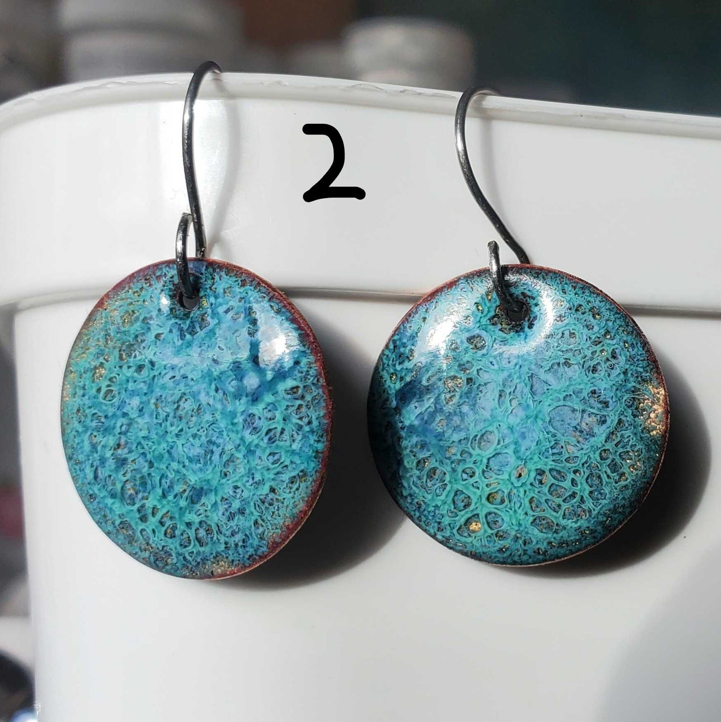 Turquoise copper enamel earrings on a white surface