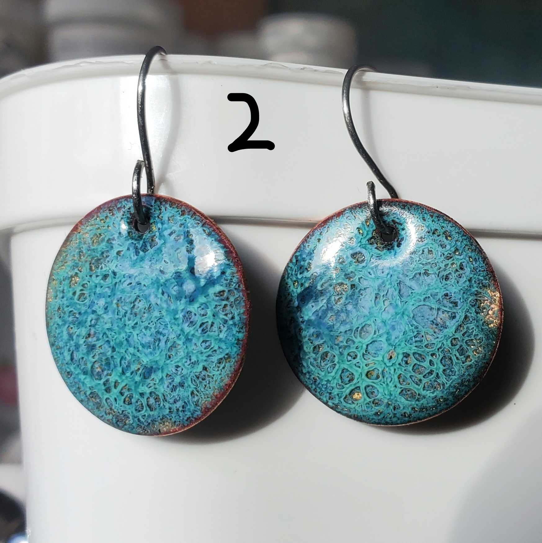 Turquoise copper enamel earrings on a white surface