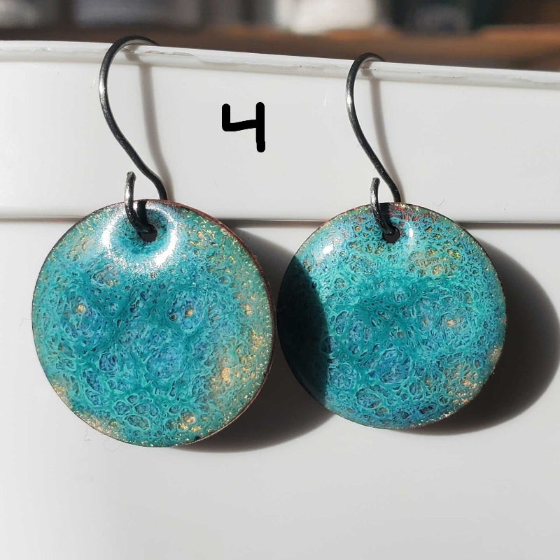 Turquoise marbled copper earrings on a white surface