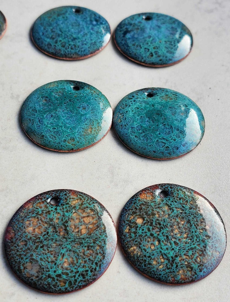 Blue copper earrings with a textured surface on a light gray background