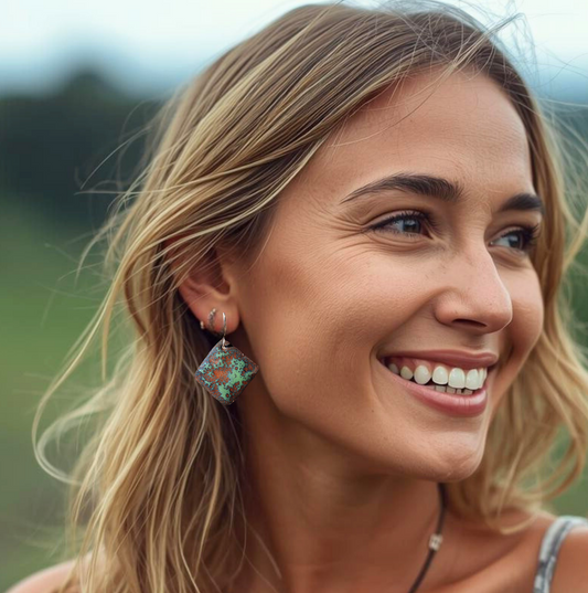 Woman wearing brown copper earrings with a blurred natural background