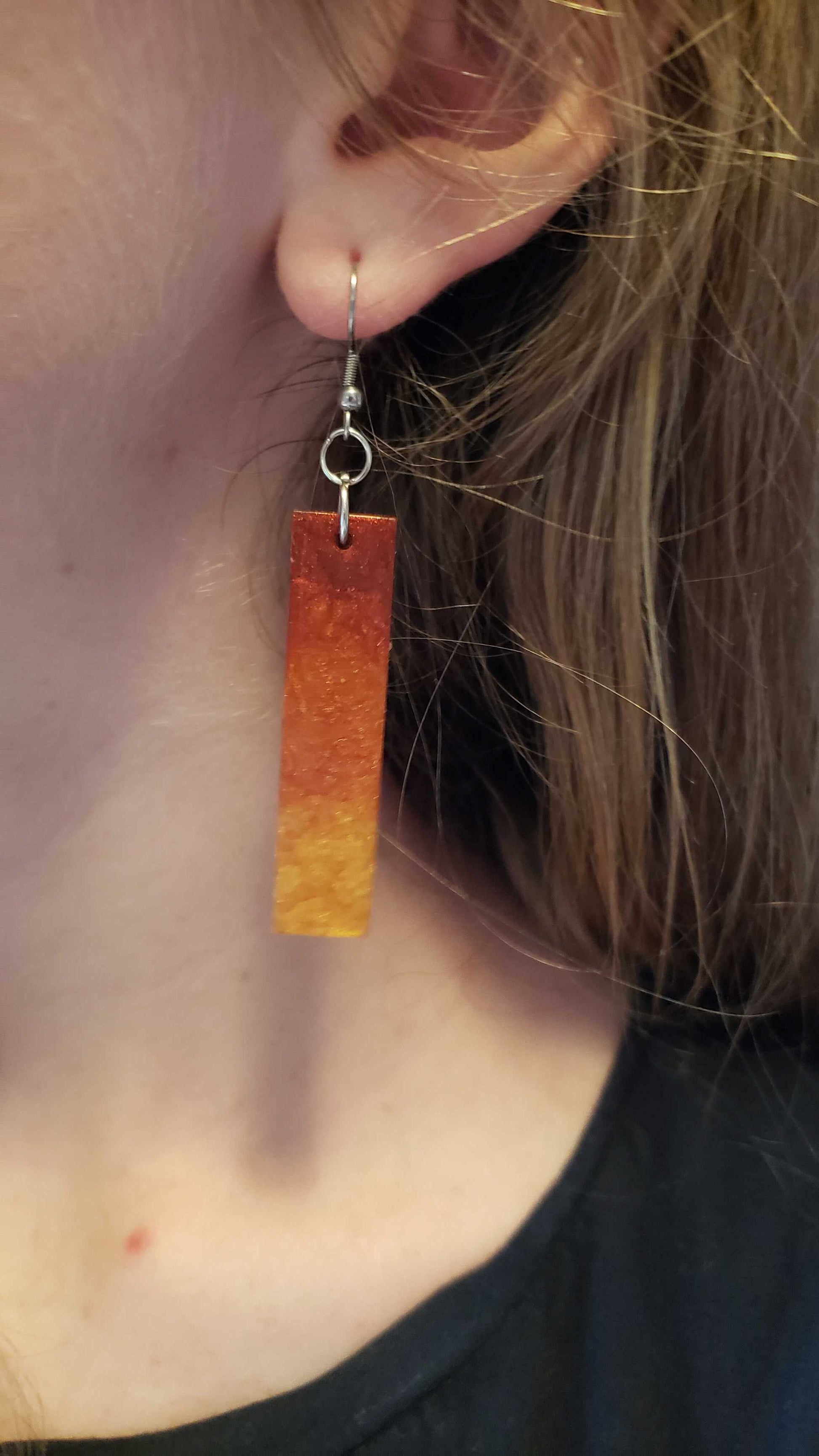 Flame fire colored earring worn by a person