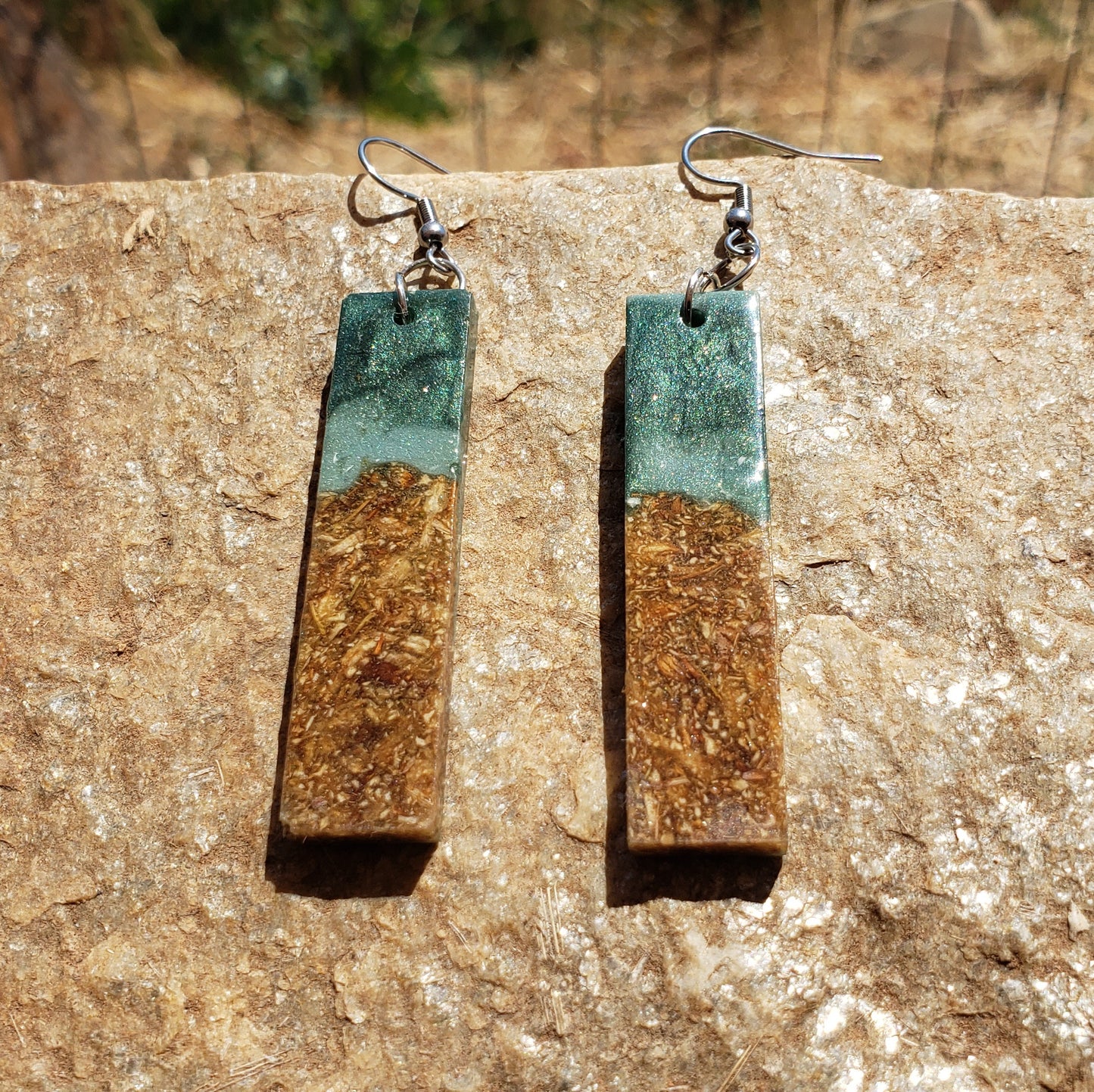 Pair of earrings with rectangular design on a stone surface