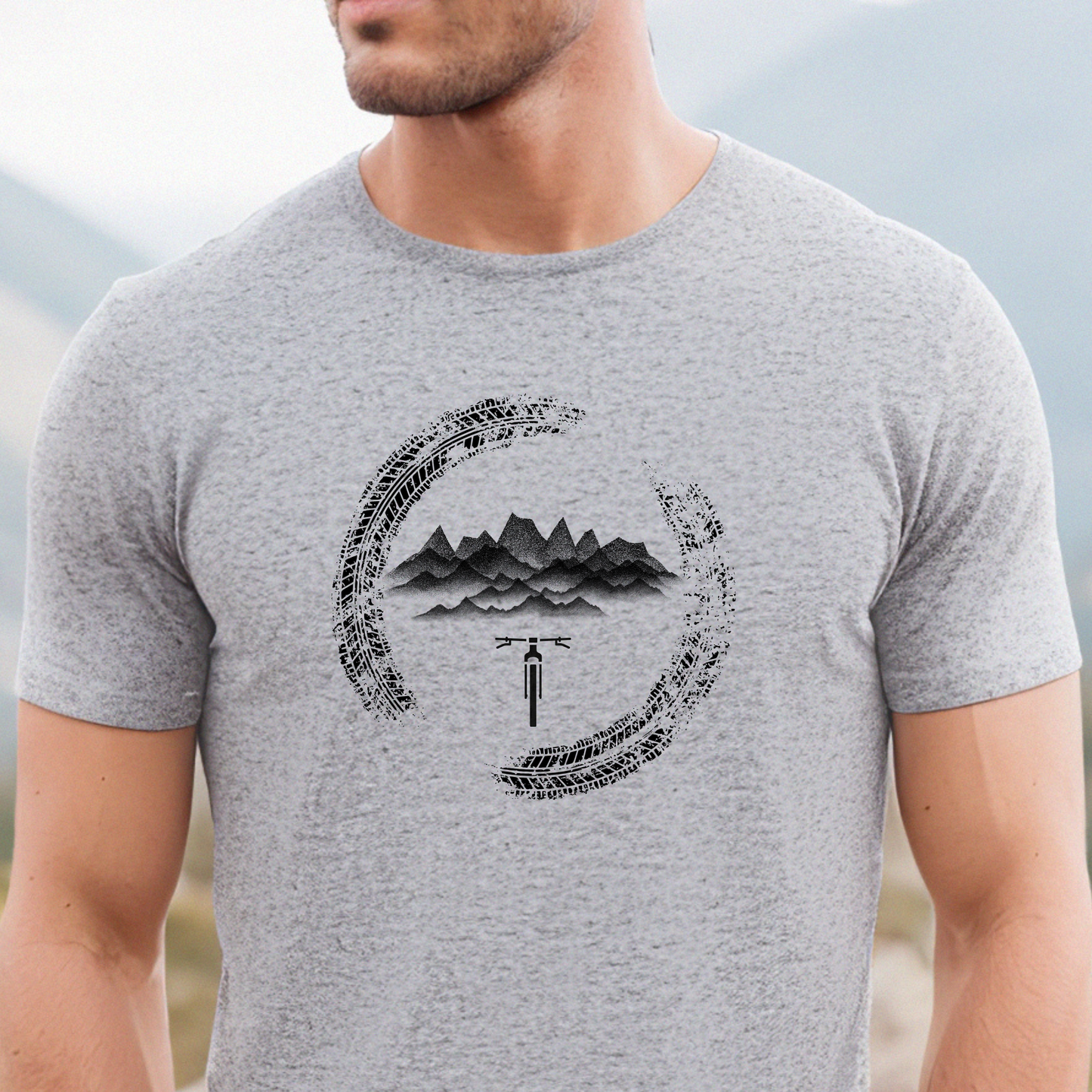Gray t-shirt with mountain and bicycle graphic worn by a person outdoors