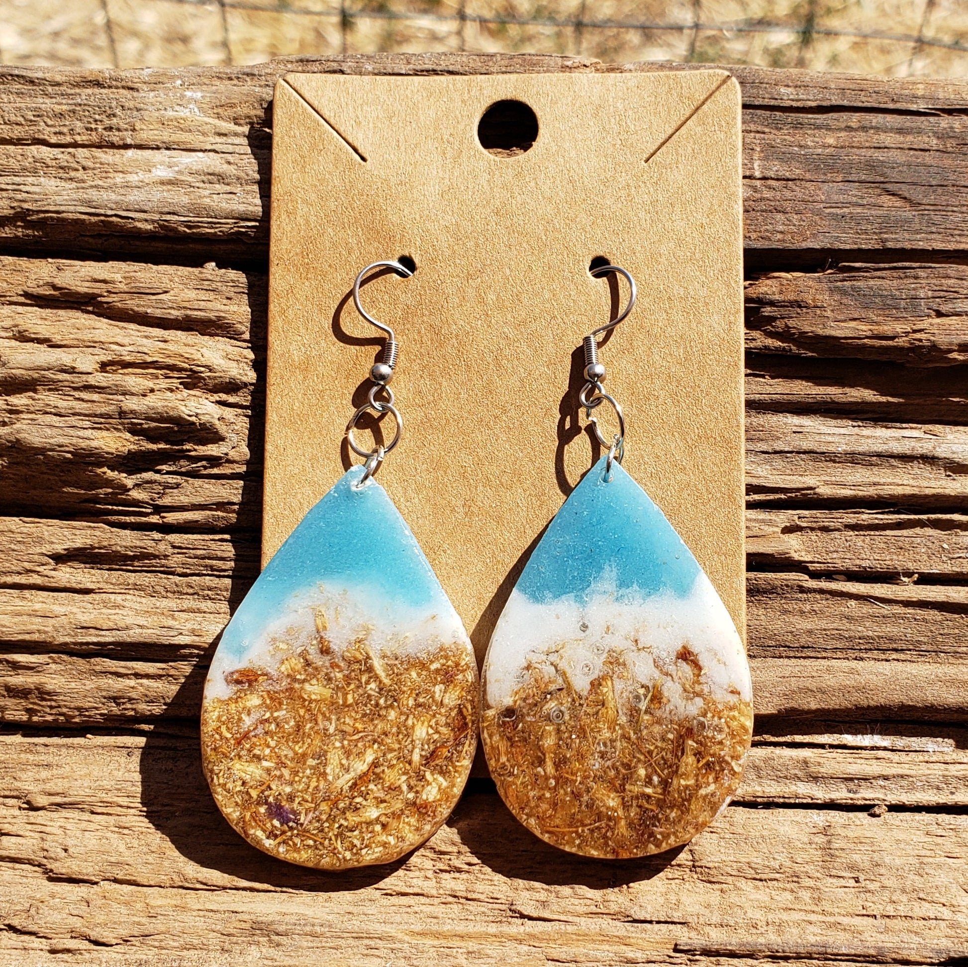 Teardrop-shaped earrings ocean inspired with gold dried flowers and white and blue design