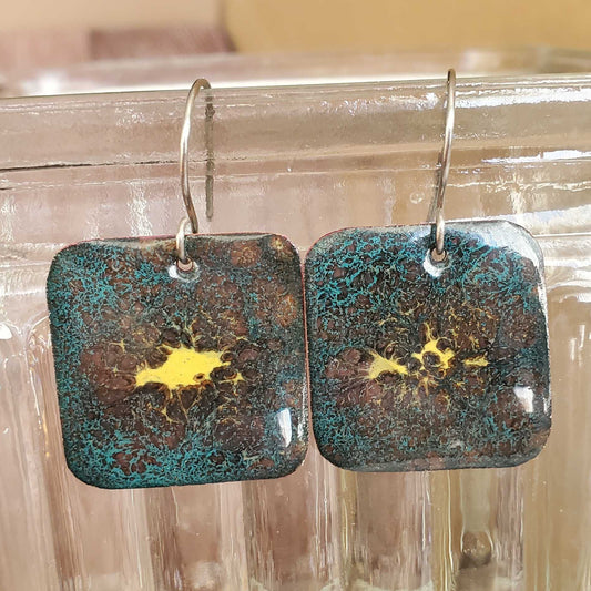 Pair of rectangular copper enamel earrings with a textured blue brown and yellow surface 