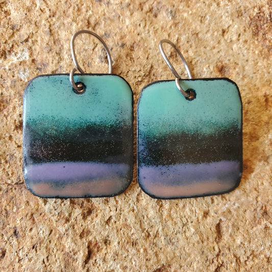 
rectangle copper enamel earrings with gradient colors on a stone surface